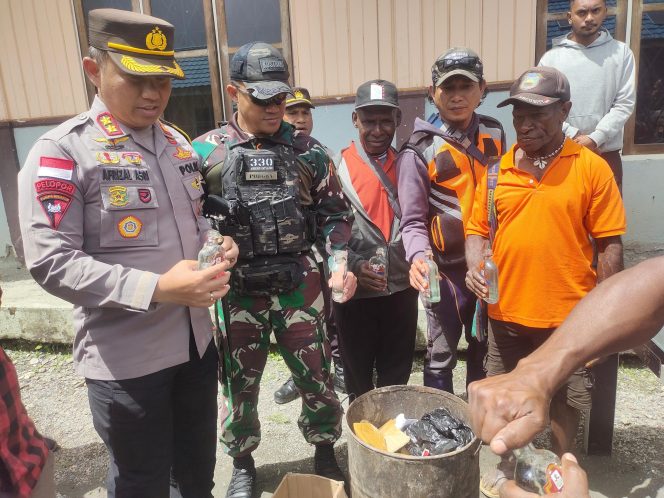 
 Satgas Yonif 330 Bekerjasama Dengan Polres Intan Jaya, Musnahkan Puluhan Miras Ilegal
