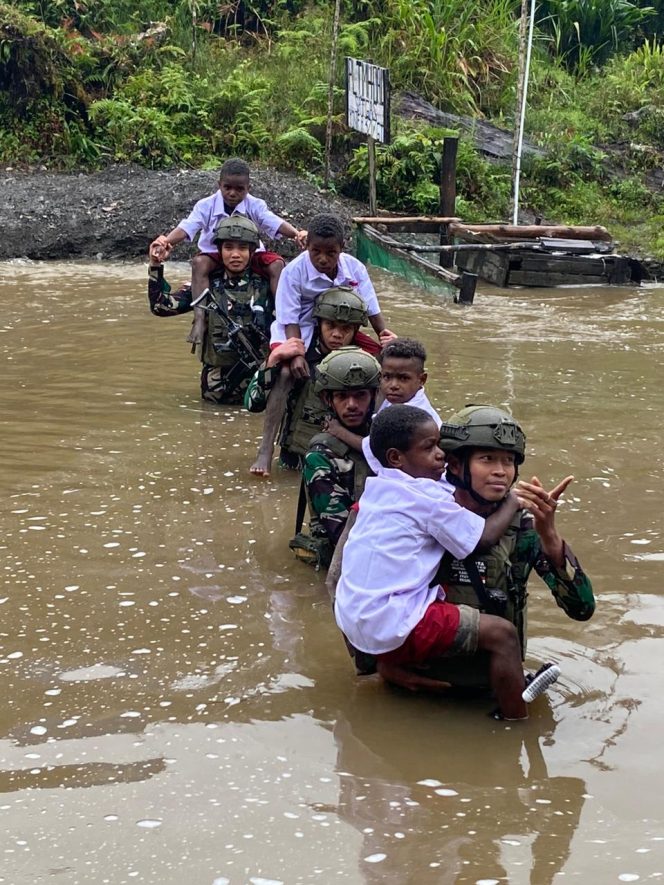 
 Satgas TNI Bantu Anak-Anak Kampung Dal Seberangi Sungai Berangkat Ke Sekolah