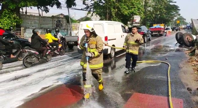 
 Truk Terguling di Flyover Pesing, Sudis Gulkarmat Jakbar Bersihkan Tumpahan Solar dan Oli